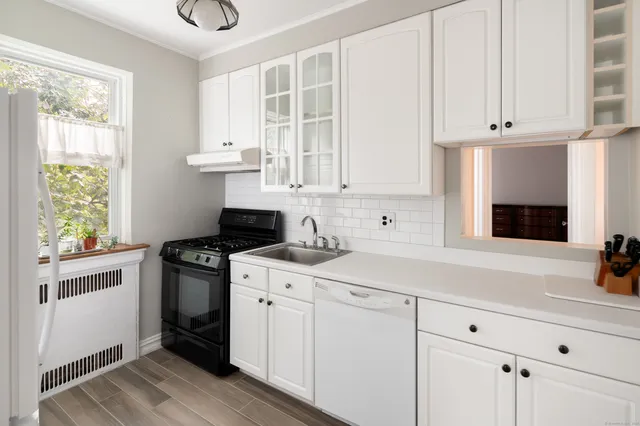a kitchen with granite countertop white cabinets and white appliances