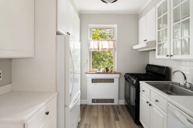 a kitchen with a stove a sink and a window