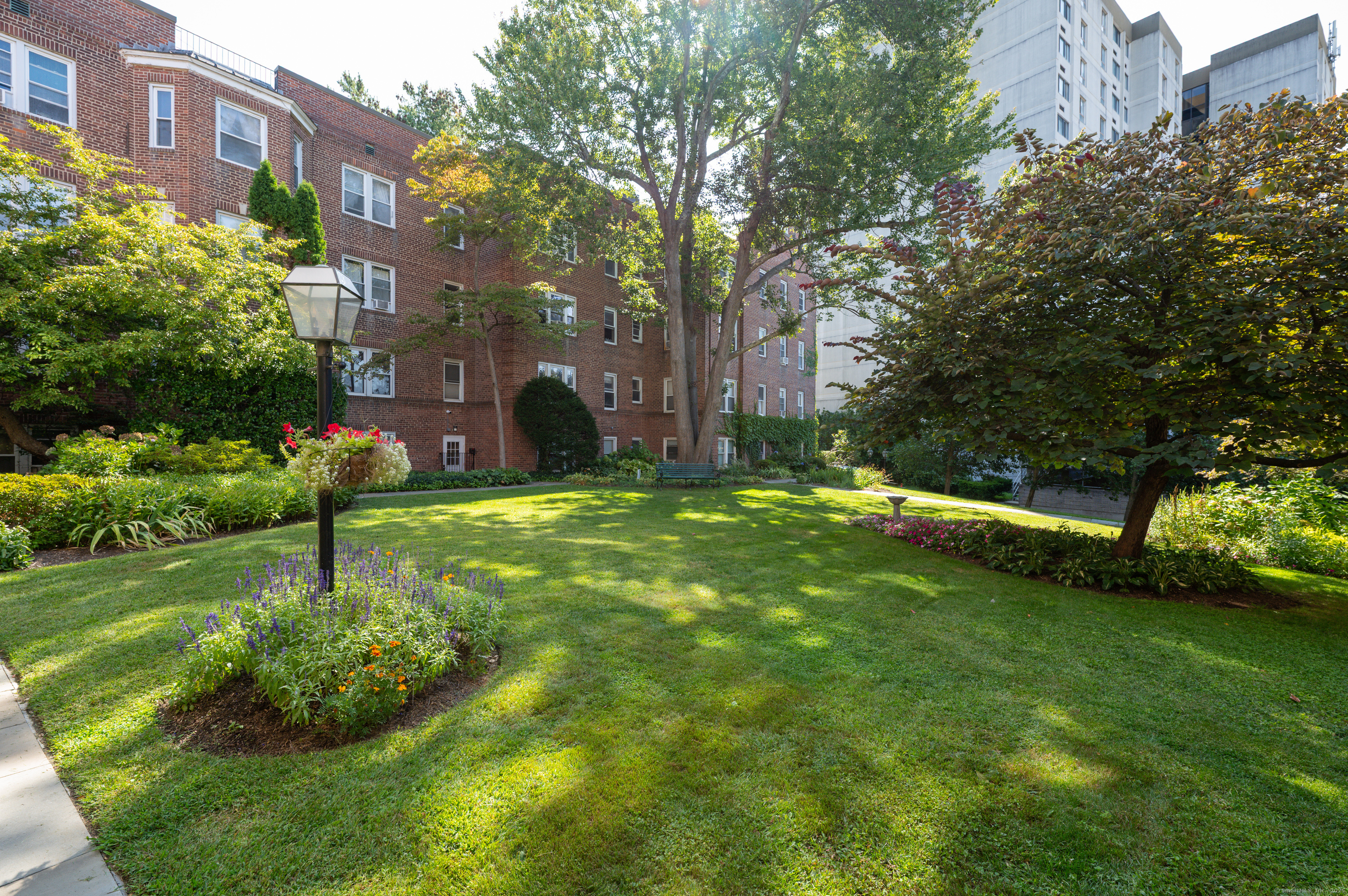 70 Strawberry Hill Avenue, Unit 22D Stamford, CT 06902 - Photo 3 of 39 a view of a garden with plants and large trees