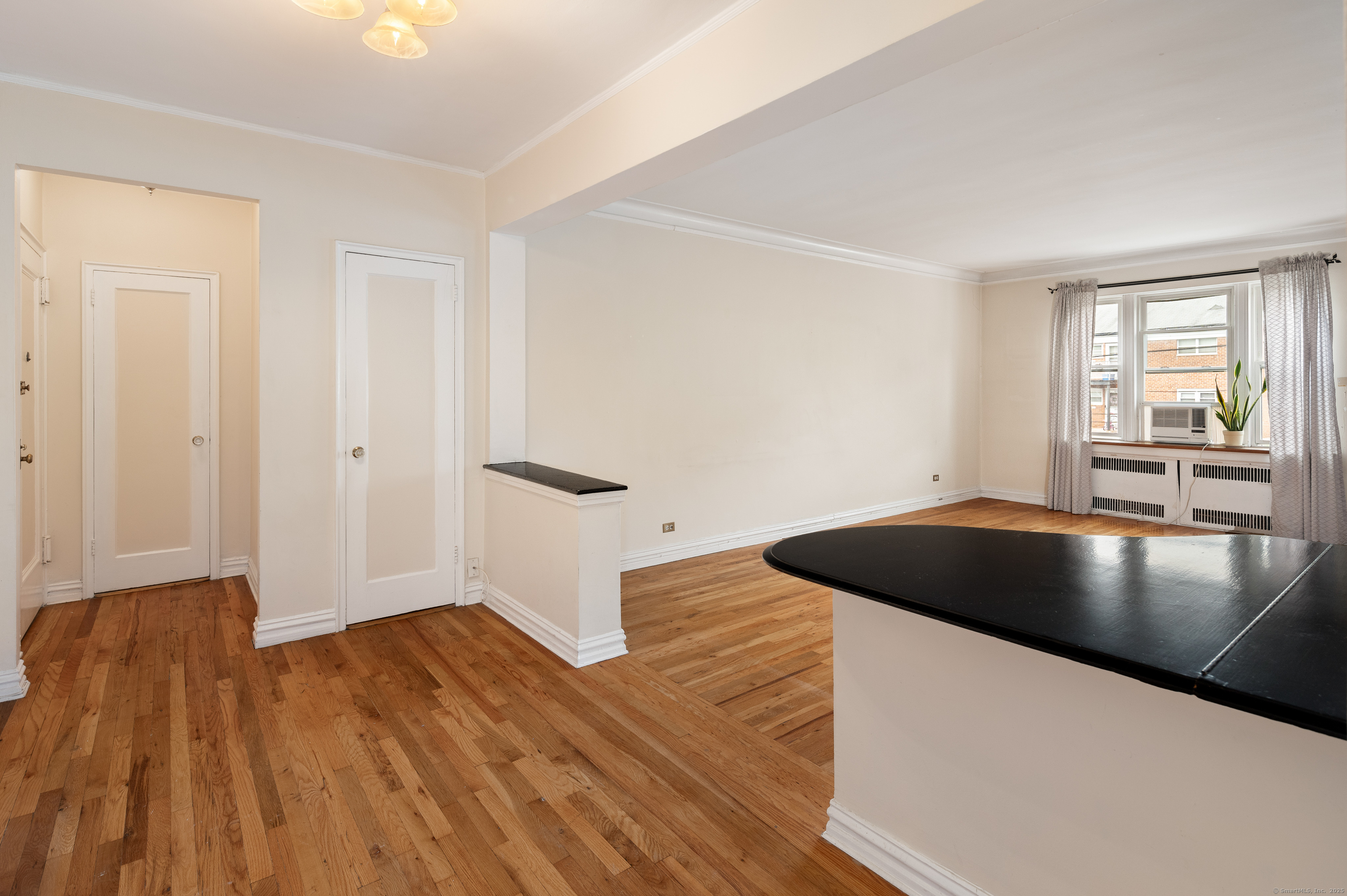 70 Strawberry Hill Avenue, Unit 22D Stamford, CT 06902 - Photo 6 of 39 an empty room with wooden floor and windows