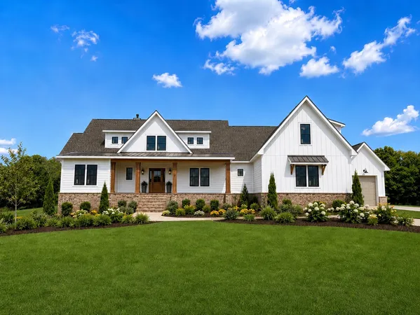 a front view of a house with a yard outdoor seating and covered with trees