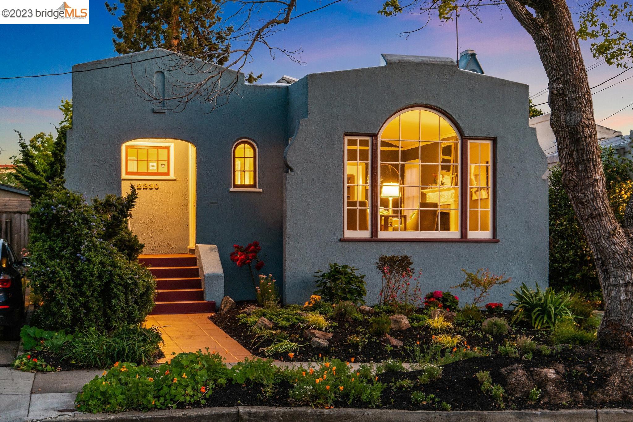 a view of a brick house with a flower garden