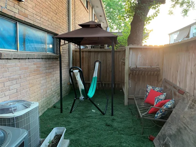 a view of a backyard with furniture and a grill