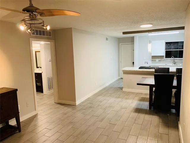 a view of a room with a flat screen tv and kitchen view