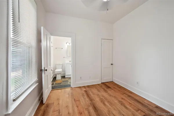 a view of a room with wooden floor and a bathroom
