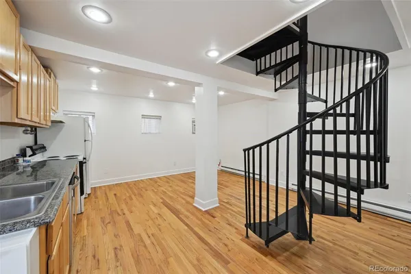 a view of a hallway with wooden floor and staircase