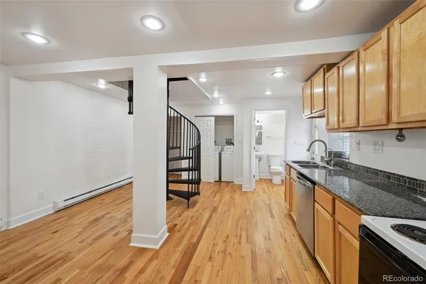 a large kitchen with stainless steel appliances granite countertop a lot of counter space and wooden floor