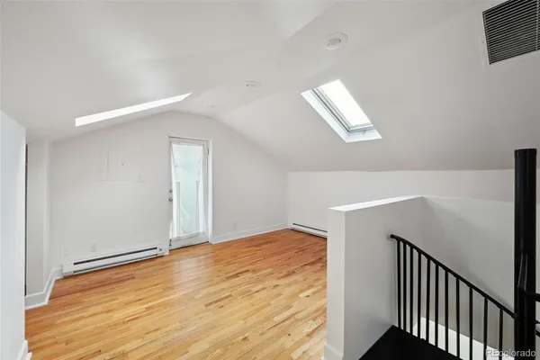a view of empty room with wooden floor