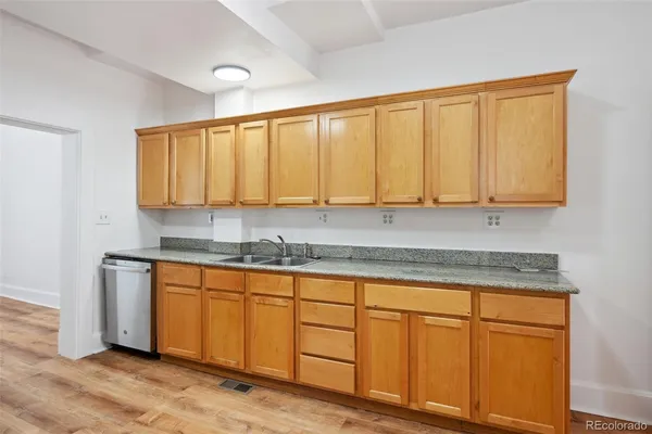 a kitchen with stainless steel appliances granite countertop cabinets and wooden floor