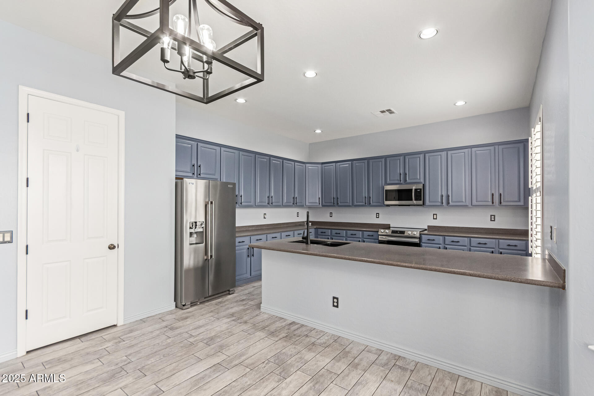 3054 South Colonial Street Gilbert, AZ 85295 - Photo 7 of 29 a kitchen with stainless steel appliances a refrigerator a stove a sink and cabinets