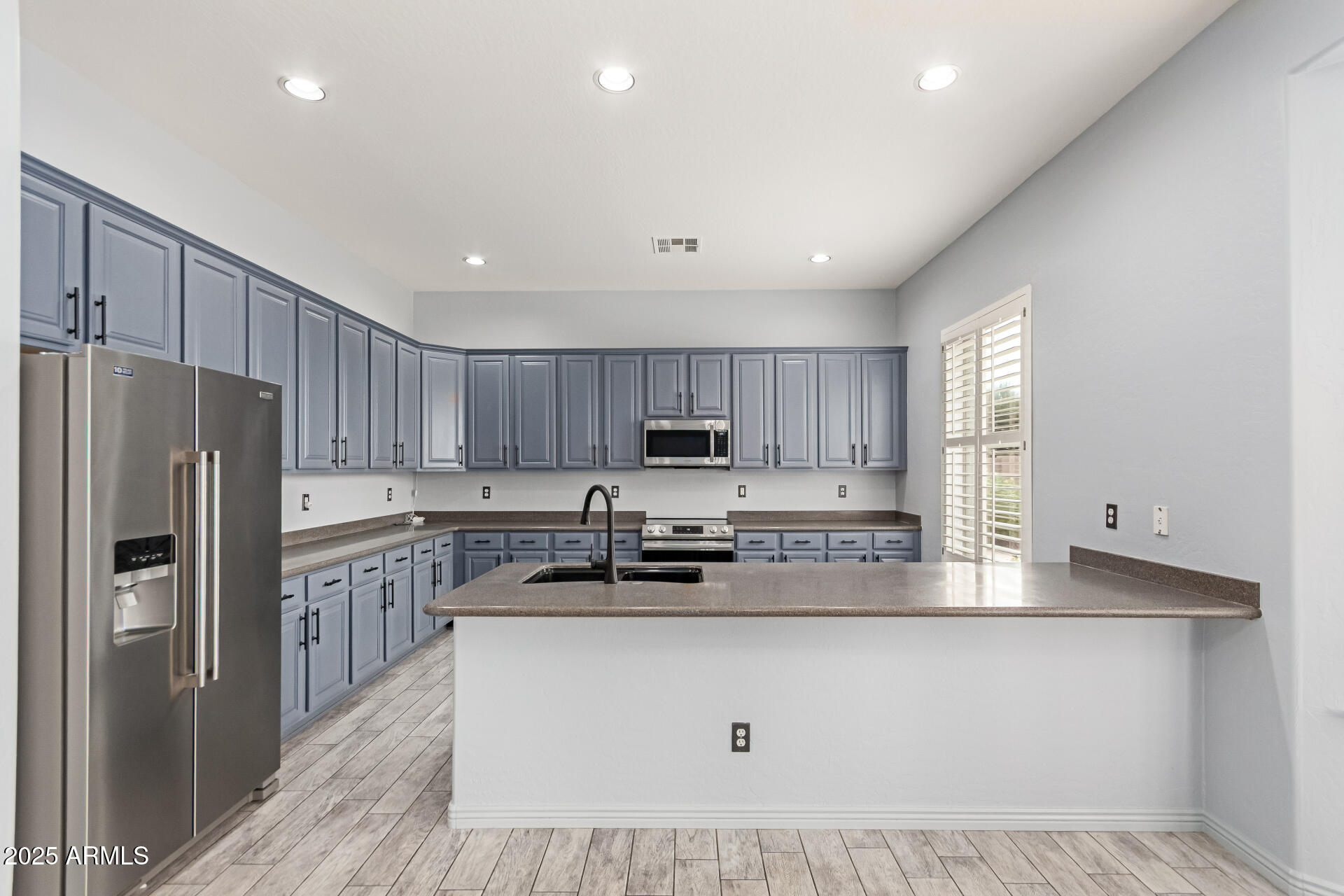 3054 South Colonial Street Gilbert, AZ 85295 - Photo 8 of 29 a kitchen with stainless steel appliances granite countertop a refrigerator sink and cabinets