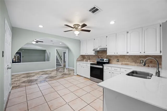 a kitchen with kitchen island granite countertop a stove sink and cabinets