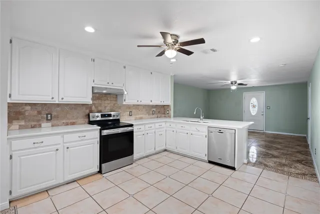 a kitchen with a stove sink and cabinets