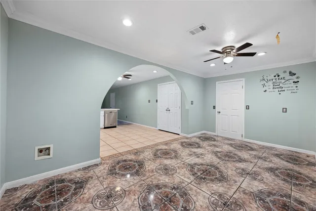 a big room with chandelier fan and windows