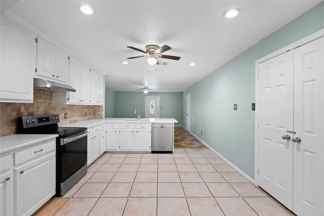 a kitchen with a stove a refrigerator and cabinets
