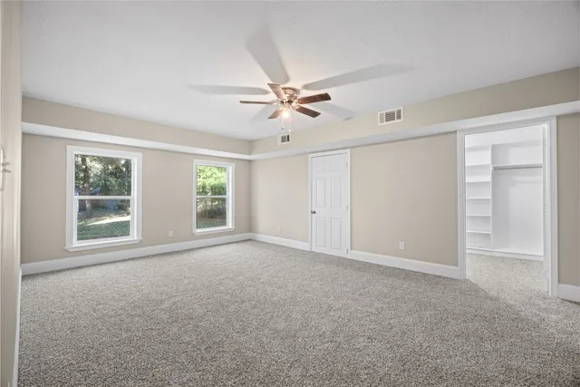 a view of an empty room with a ceiling fan