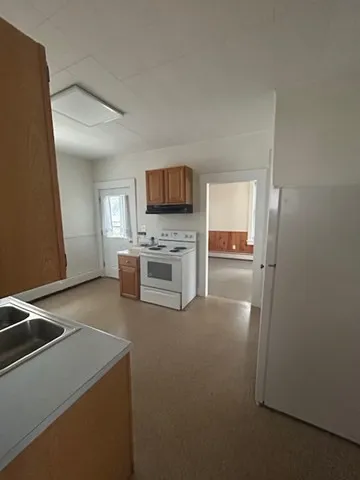 a kitchen with a refrigerator and a stove top oven