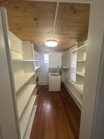 a kitchen with a refrigerator and white cabinets