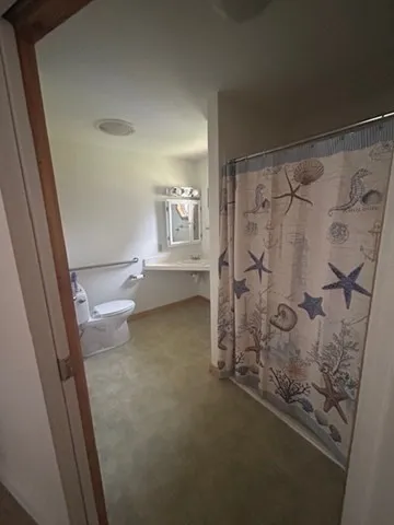 a bathroom with a granite countertop sink toilet and shower