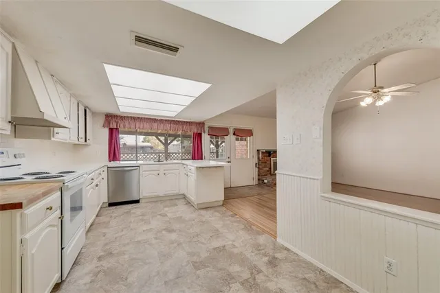 a kitchen with granite countertop a sink and white cabinets