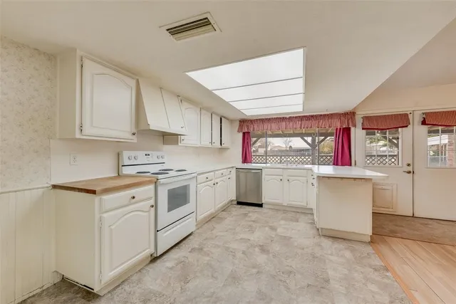a kitchen with white cabinets and white appliances