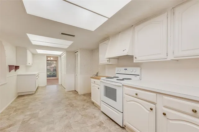 a kitchen with white cabinets and white appliances