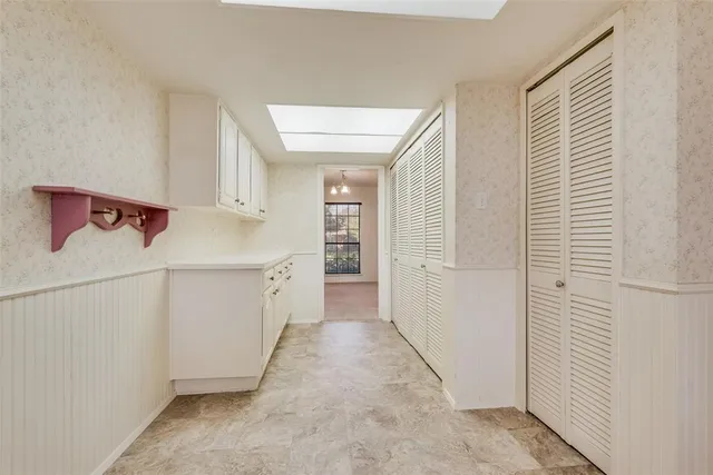 a view of a hallway with white cabinets