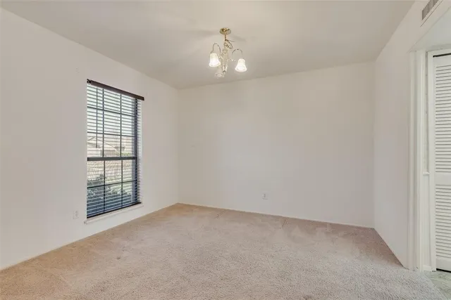 an empty room with windows and cabinet