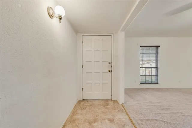 a view of an empty room with windows and cabinet