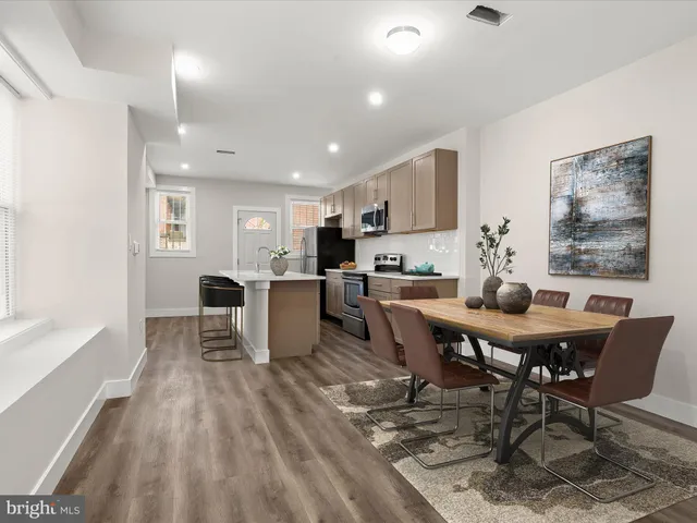 a view of a dining room with furniture and a kitchen