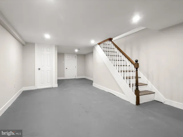 an empty room with staircase and white walls