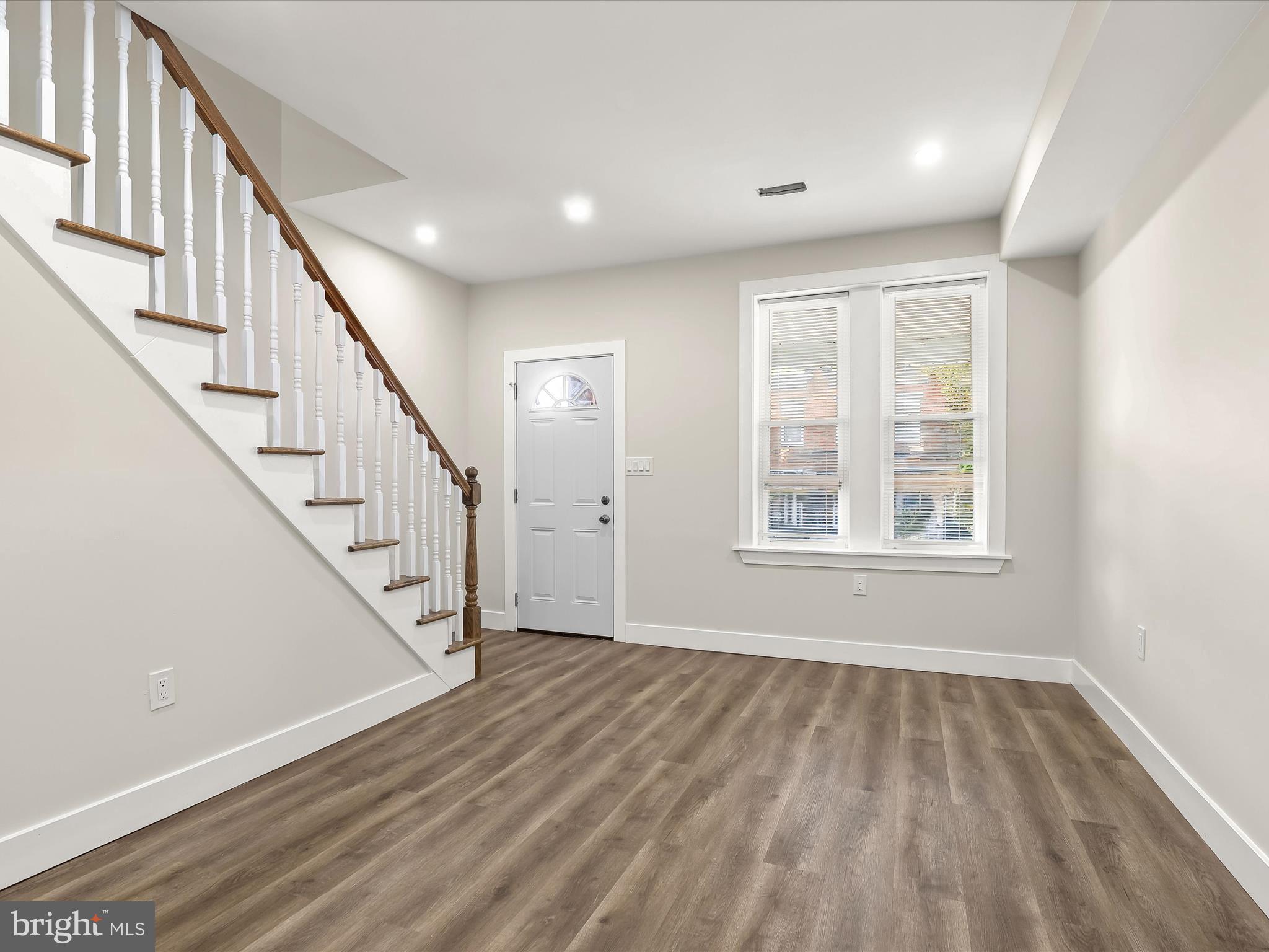 2800 East Chase Street Baltimore, MD 21213 - Photo 4 of 37 a view of an empty room with wooden floor and stairs