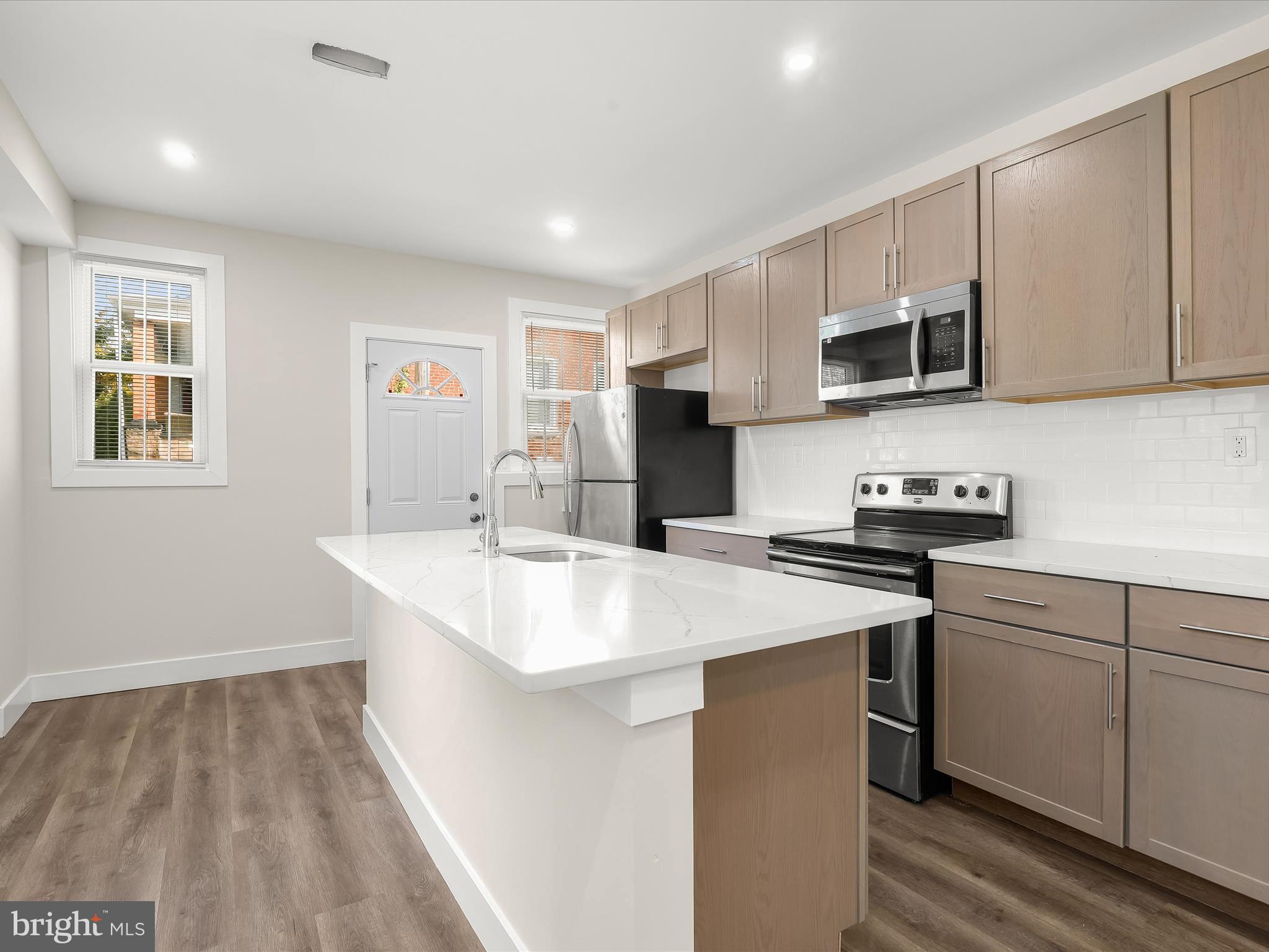 2800 East Chase Street Baltimore, MD 21213 - Photo 7 of 37 a kitchen with kitchen island a sink appliances and cabinets