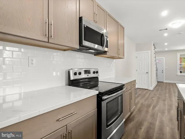 a kitchen with stainless steel appliances a stove microwave and sink