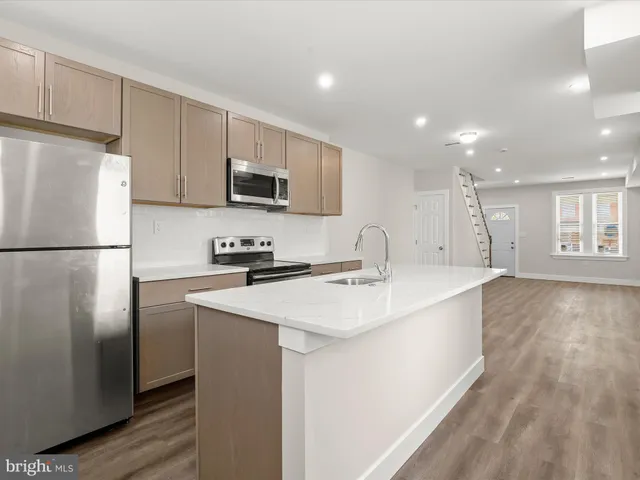 a kitchen with kitchen island a sink stainless steel appliances and cabinets