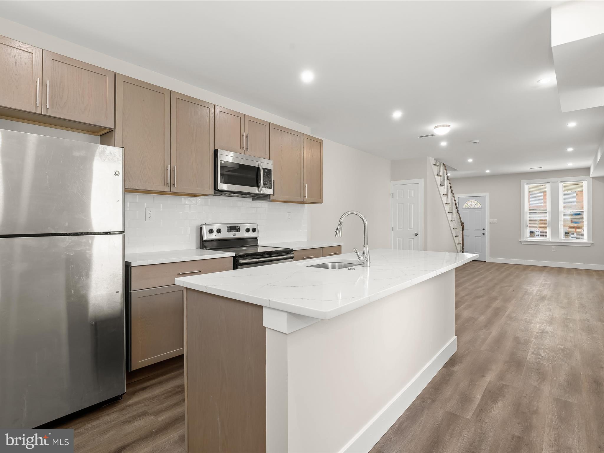 2800 East Chase Street Baltimore, MD 21213 - Photo 10 of 37 a kitchen with kitchen island a sink stainless steel appliances and cabinets