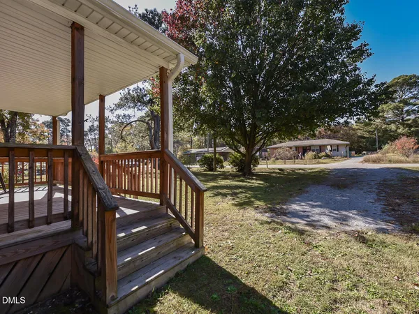 a view of a wooden deck and a yard with wooden fence