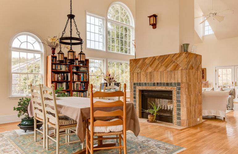 491 Butter Lane Bridgehampton, NY 11932 - Photo 10 of 39 a dining room with furniture a fireplace and a chandelier