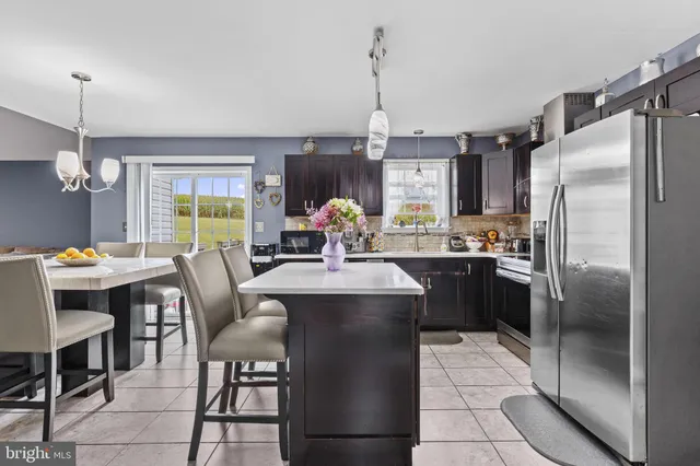 a kitchen with a table chairs refrigerator and cabinets