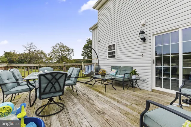 a view of a roof deck with table and chairs and wooden floor