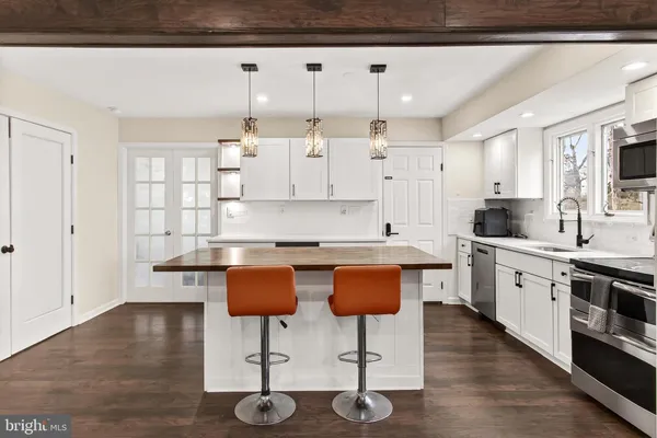 a kitchen with stainless steel appliances granite countertop a sink a stove and a wooden floors