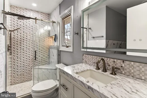 a kitchen with stainless steel appliances granite countertop a table chairs and white cabinets