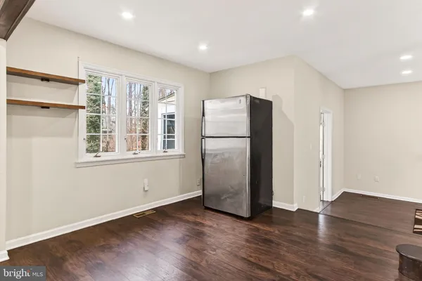 a view of kitchen with stainless steel appliances refrigerator and wooden floor