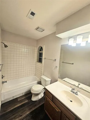a living room with a fireplace furniture a ceiling fan and a window
