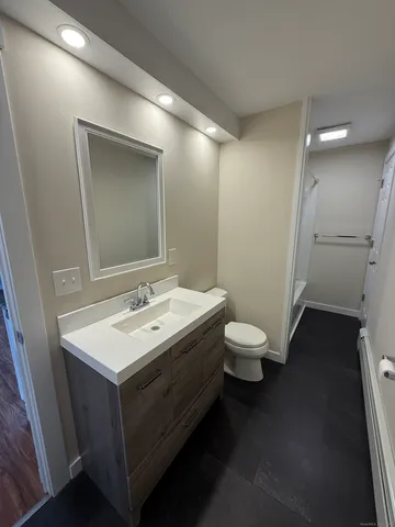 a bathroom with a toilet a sink and mirror