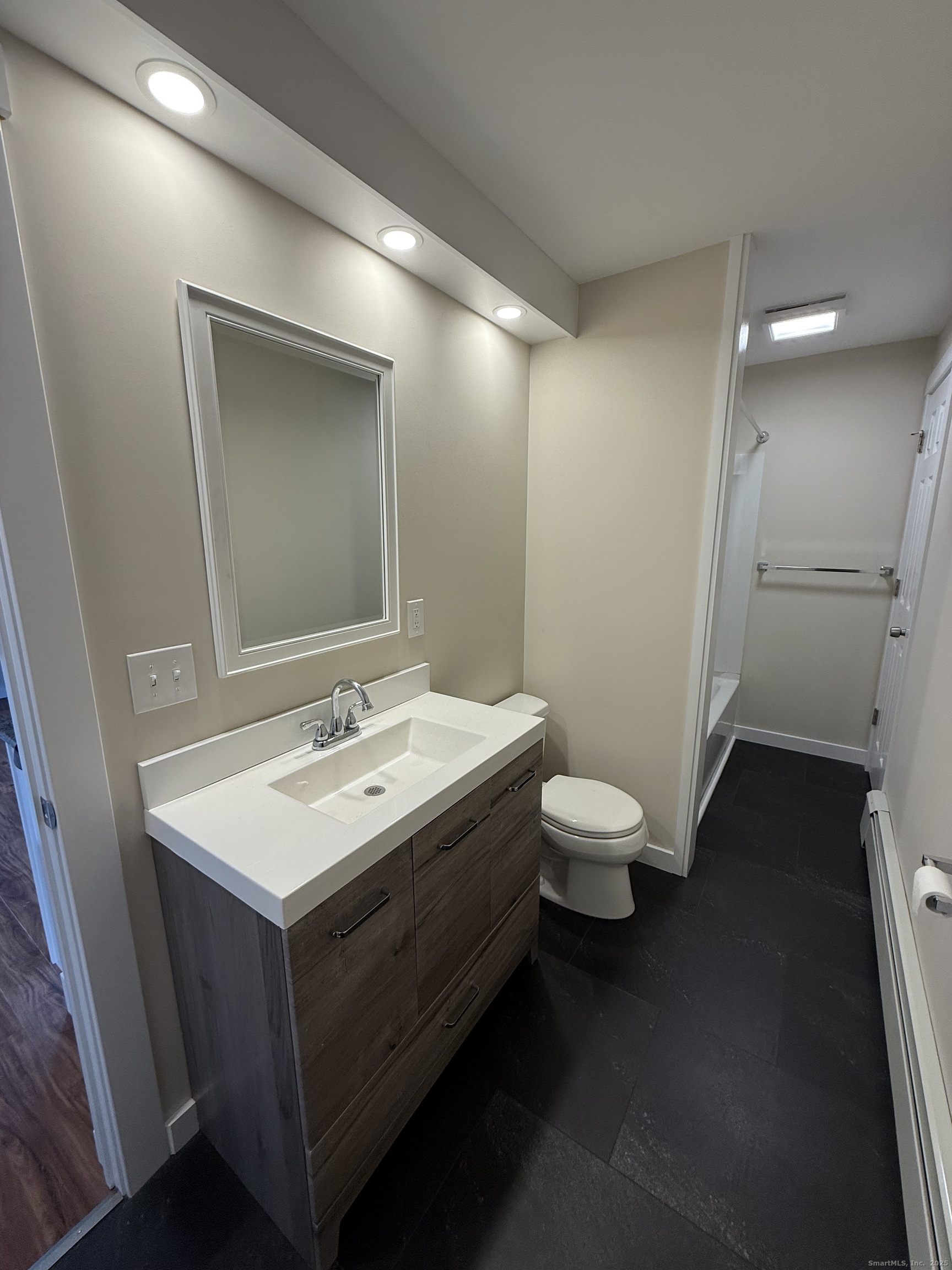 25 A Bridge Street, Unit 3 New Milford, CT 06776 - Photo 13 of 15 a bathroom with a toilet a sink and mirror