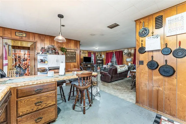 a room with stainless steel appliances kitchen island granite countertop furniture and a window