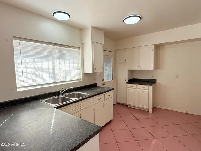 a kitchen with a sink cabinets and window