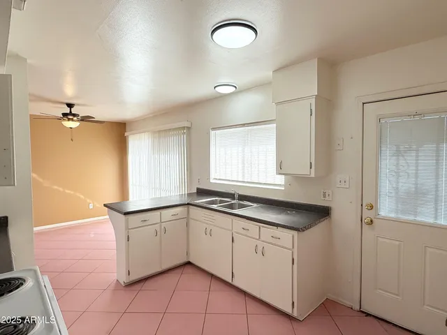 a kitchen with granite countertop a sink a stove and cabinets