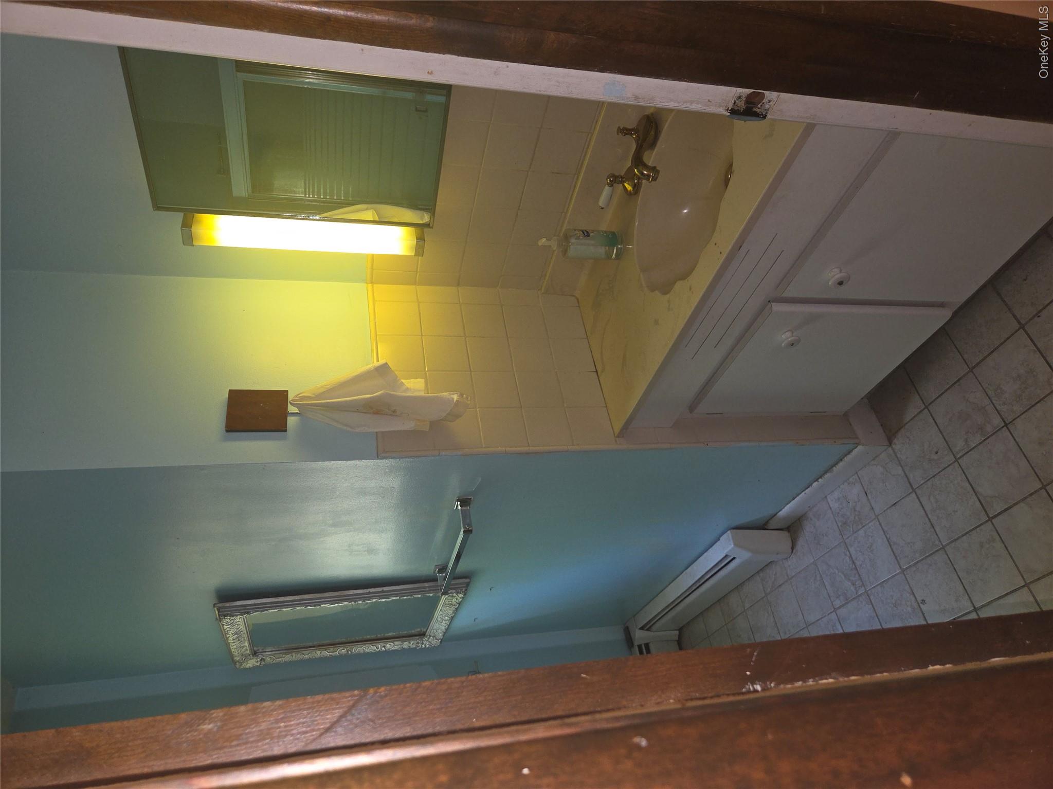 63 Otens Road Ellenville, NY 12428 - Photo 17 of 32 a bathroom with a granite countertop sink a toilet a mirror and vanity